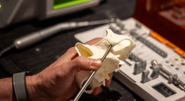 An attendee places a zygomatic implant in a dry hands-on model.