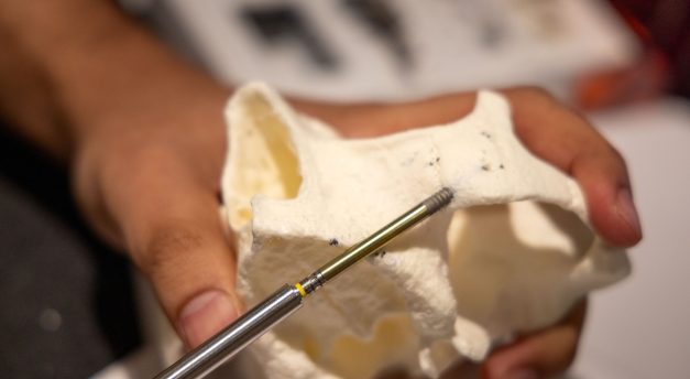 An attendee places a zygomatic implant in a dry hands-on model.